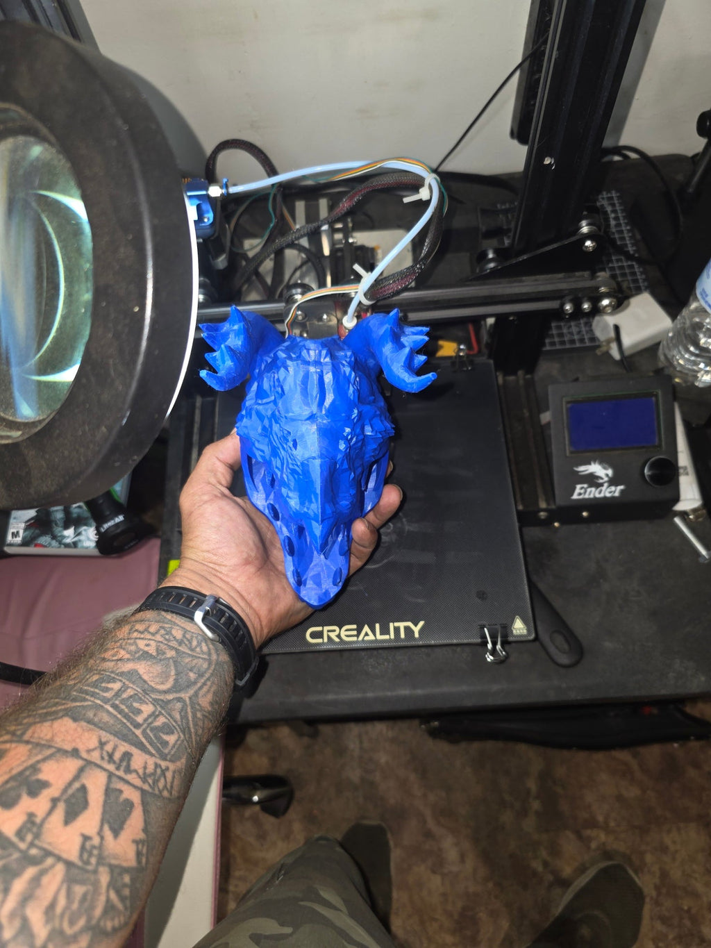 3D printed blue dragon skull pen holder held in hand — front view showing teeth and horns