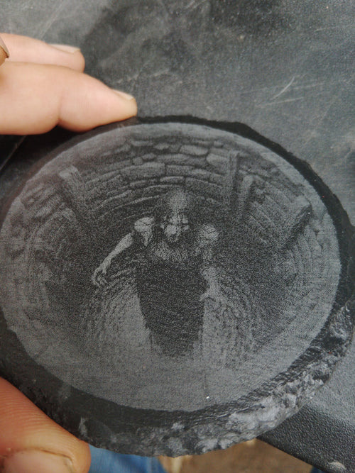 Custom laser engraved slate — circular piece with detailed figure engraving